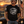 Man wearing FreedomBuilt 2nd Amendment 1776 Come and Take It graphic tee in Black Heather, printed with soft water-based ink, standing beside a classic black Camaro at sunset.